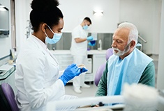 A dentist showing dentures to her patient